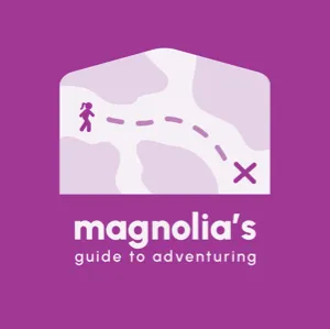 Logo for ‘Magnolia’s Guide to Adventuring,’ featuring a whimsical map design with a path leading to an ‘X’ destination, on a purple background
